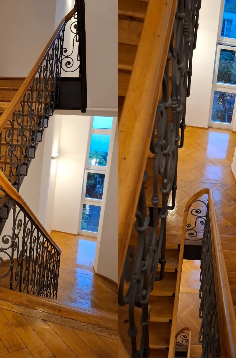 Gereinigtes Treppenhaus mit Holzstufen und Schmiedeeisengeländer